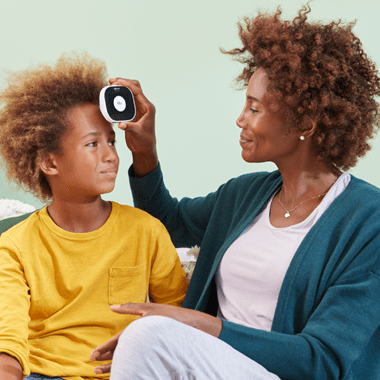 mother using TytoCare to take sons temperature 